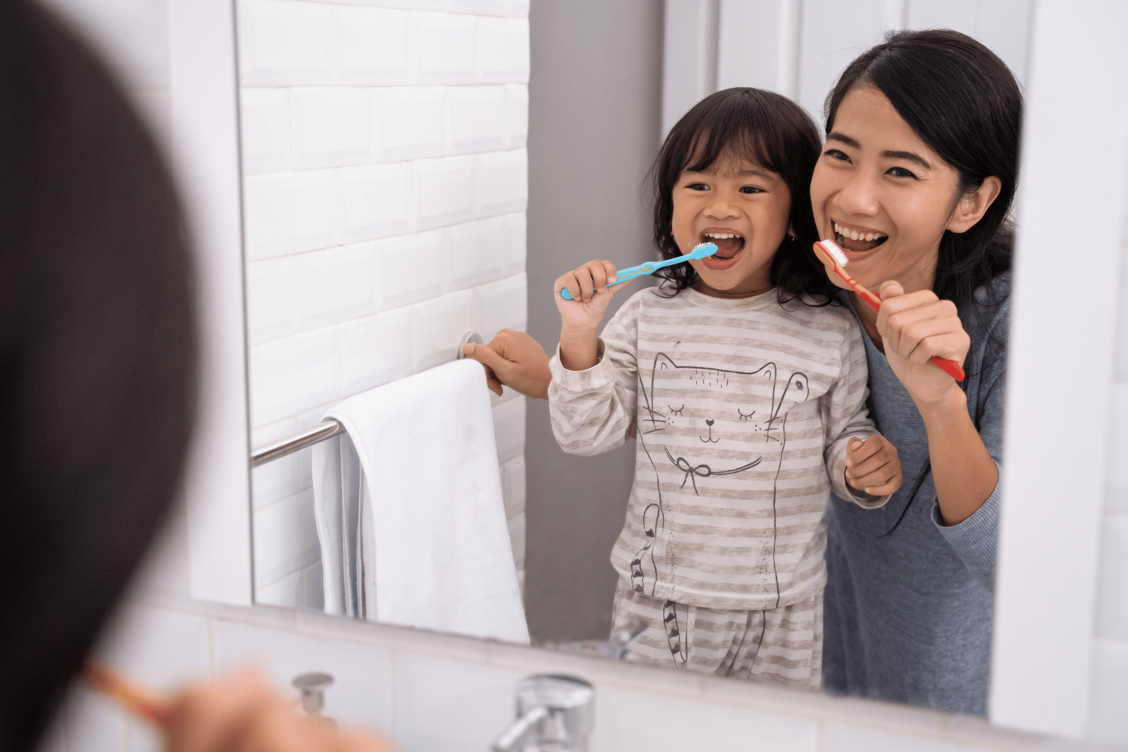 mom brushing teeth with child